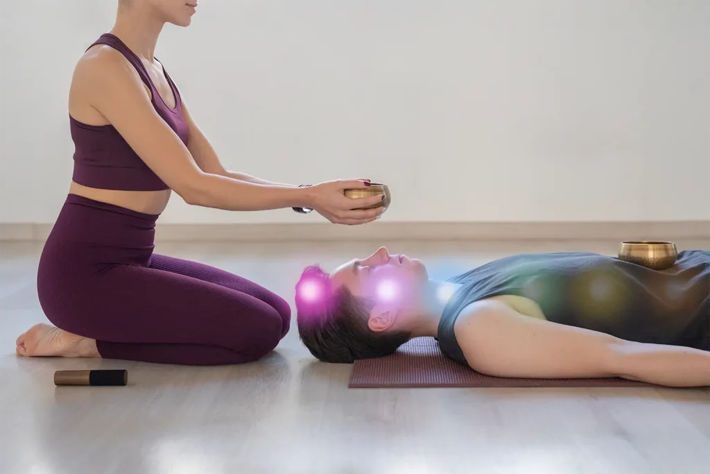 Femme réalisant un soin énergétique sur les chakras d’un homme